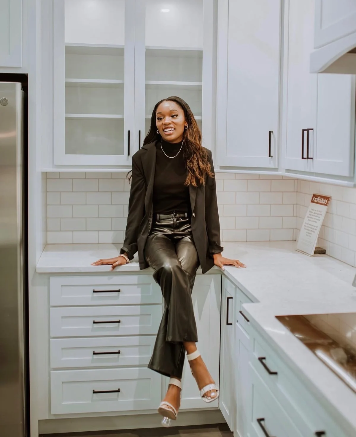 Attiya Smith seated on a kitchen counter in a bright modern home